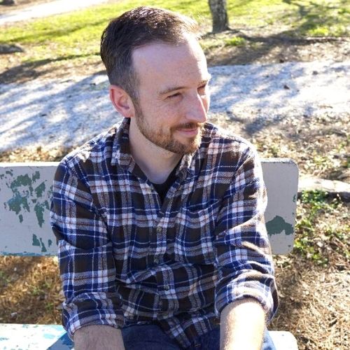 Man smiling on bench.