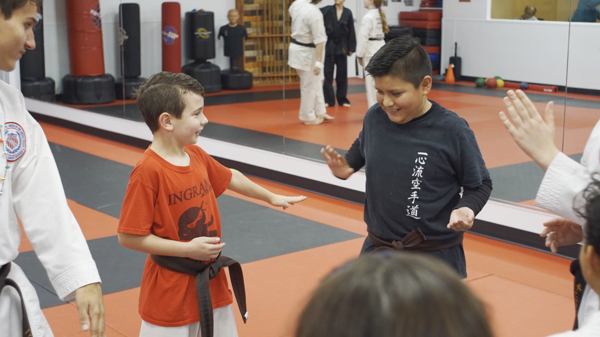 Kids and teens playing a karate game of "Ninja Tag" in a circle.